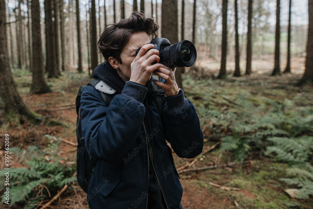 The photographer pay attention to take a photo in a beautiful forest. Adventure travel with camera in the nature. The photographer pay attention to take a photo in a beautiful forest. Adventure travel with camera in the nature.
