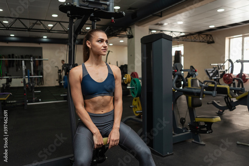 Young fit woman resting after hard workout in gym