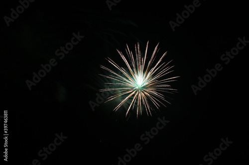 Single bright green and white, alone in upper right, firework isolated on black, bright colorful, copy space.