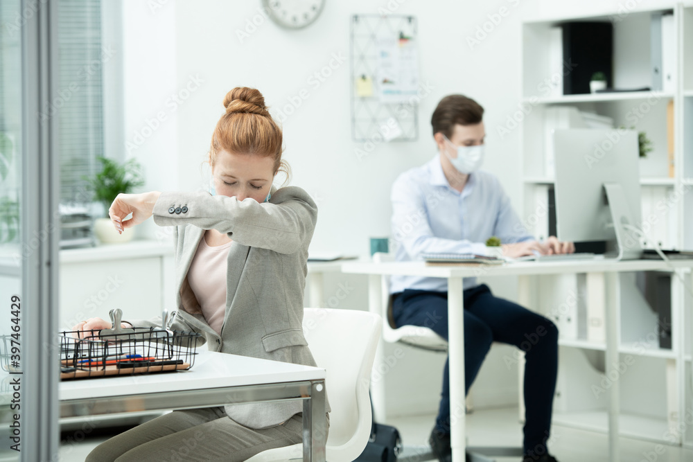 Obraz premium Young female office manager in suit and protective mask going to sneeze