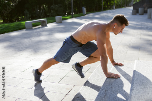Young athletic man doing warm-up before outdoor workout. Healthy lifestyle. Fitness concept © splitov27