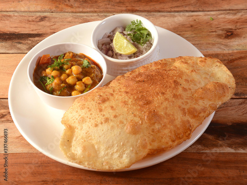Chole Bhature, spicy Chick Peas curry also known as Chole or Channa Masala is traditional North Indian main course recipe and usually served with fried puri or Bhature, selective focus