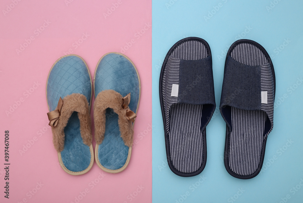Men's and women's indoor cozy slippers on a blue-pink pastel background. Top view Men's and women's indoor cozy slippers on a blue-pink pastel background. Top view