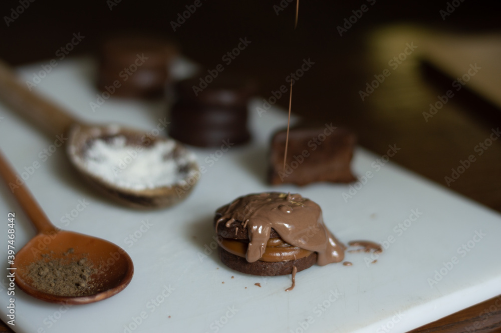 Uruguayan and Argentinian alfajor in dark scenery. Typical South American food. Chocolate cake with dulce de leche filling. Uruguay. Argentina Uruguayan and Argentinian alfajor in dark scenery. Typical South American food. Chocolate cake with dulce de leche filling. Uruguay. Argentina