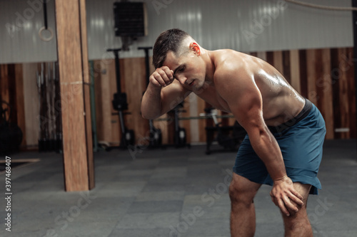 Portrait of tired male athlete after heavy intense workout in gym