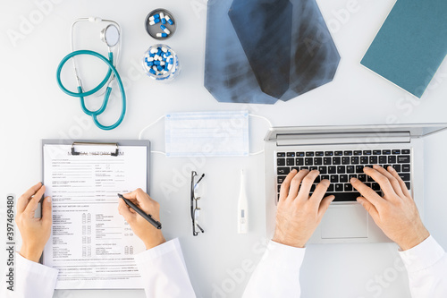 Flatlay of hands of male and female clinicians making medical notes and typing