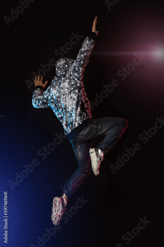 Young boy jumping on black background