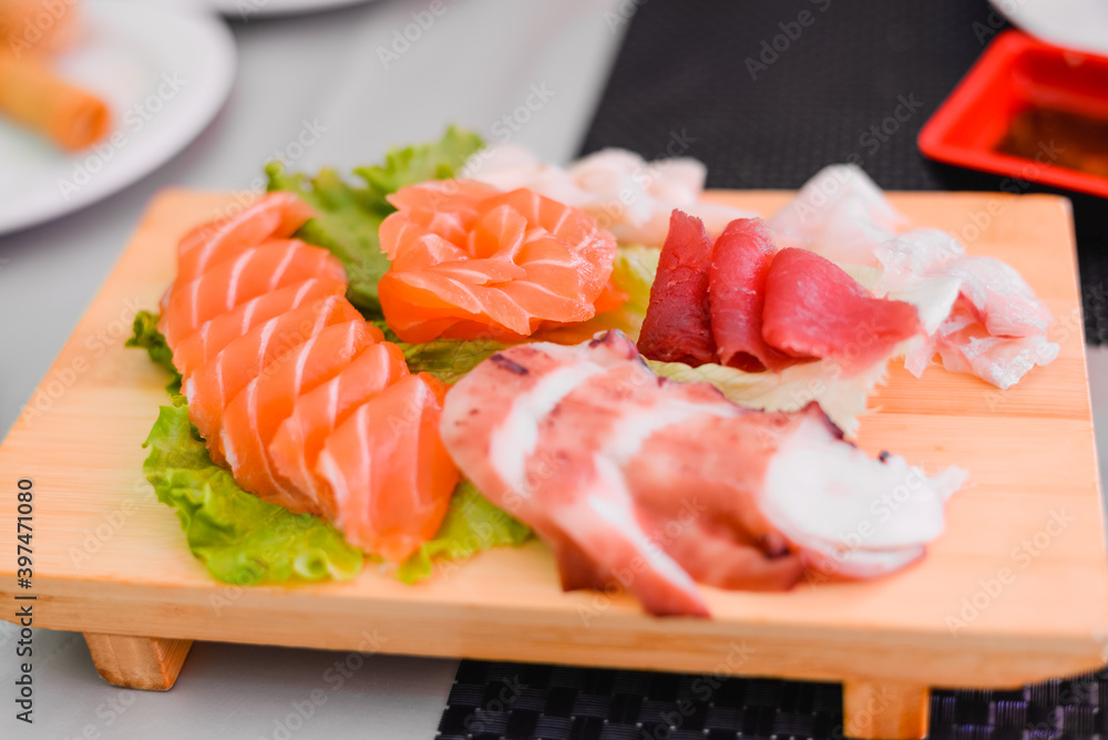 Japan of raw fresh fish fillet, sashimi mix salmon and tuna set on wooden board Japan of raw fresh fish fillet, sashimi mix salmon and tuna set on wooden board
