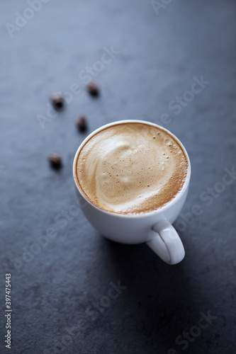 Cup of coffee on dark stone background. Close up.