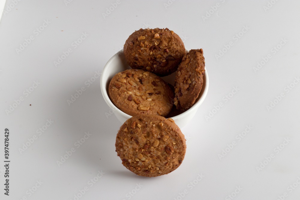 home made cookies in india stacked in a white cup and white background, biscuits for eating during free time and during rainy season, cookies with peanuts burnt more for party home made cookies in india stacked in a white cup and white background, biscuits for eating during free time and during rainy season, cookies with peanuts burnt more for party