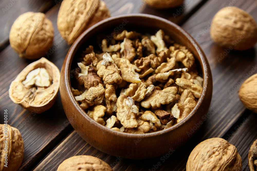 Walnut half and seeds and bowl on wooden table Walnut half and seeds and bowl on wooden table