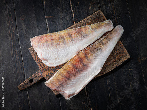 Fresh pikeperch fillet on a wooden cutting board. Top view. 