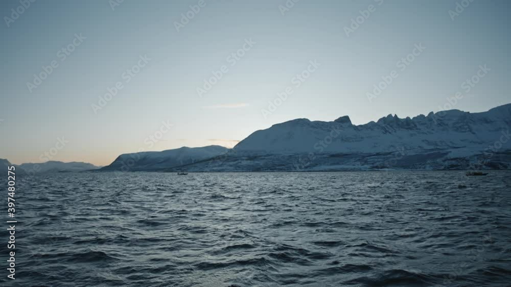 Small boats searching orca and humpback whale near fjords of Tromso in winter. Dark Blue water and mountains. Exclusive documentary footage Filmed RED camera during a scientific expedition to Norway Small boats searching orca and humpback whale near fjords of Tromso in winter. Dark Blue water and mountains. Exclusive documentary footage Filmed RED camera during a scientific expedition to Norway