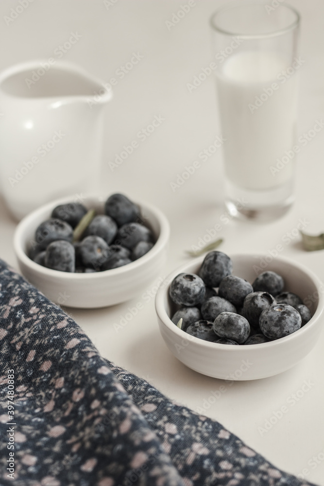 Fresh blueberries, glass of milk and milk jug on white background. Morning concept Fresh blueberries, glass of milk and milk jug on white background. Morning concept