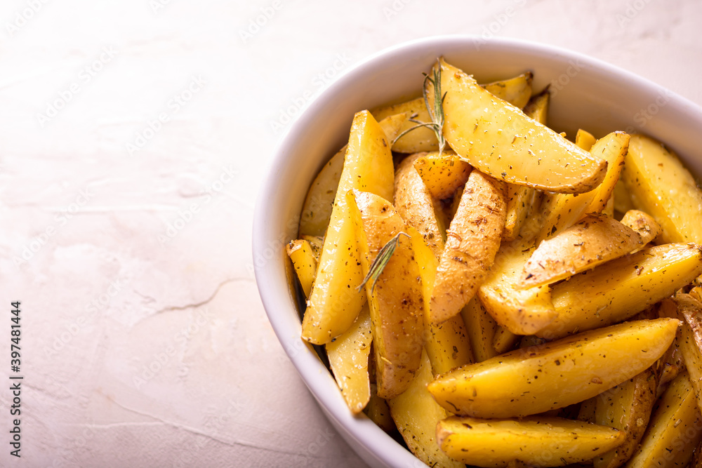 Delicious slices of baked potatoes with rosemary and oil. Delicious slices of baked potatoes with rosemary and oil.