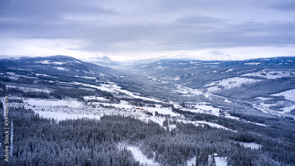 Flying over winter wonderland with frozen creeks and snow clothed trees. Shot with a drone in Hallingdal, Gol. 