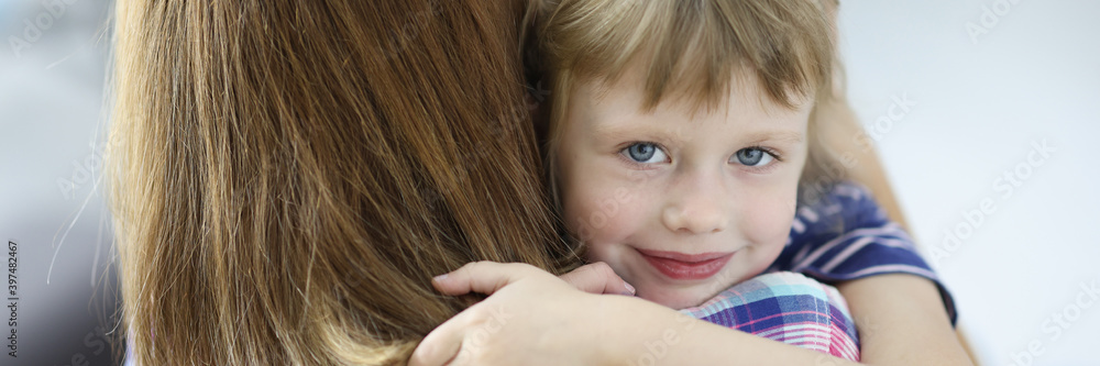 Little beautiful girl hugs her mother and smiling portrait. Social guarantees for women with children during divorce concept. Little beautiful girl hugs her mother and smiling portrait. Social guarantees for women with children during divorce concept.