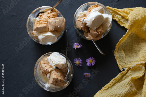Ice cream and crème brлеlée in ice-cream bowls, on a dark slate background.
