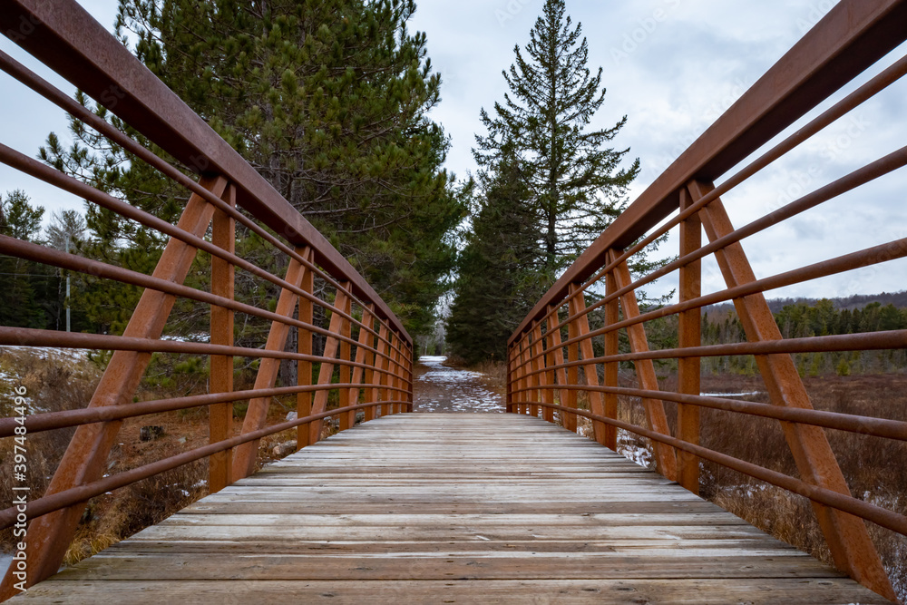 On a wooden footbridge with rusty steel railings