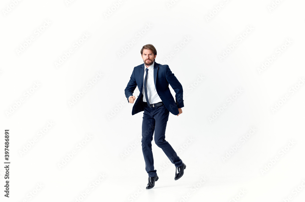 a man on a light background walks and jumps to the side in full growth business finance a man on a light background walks and jumps to the side in full growth business finance