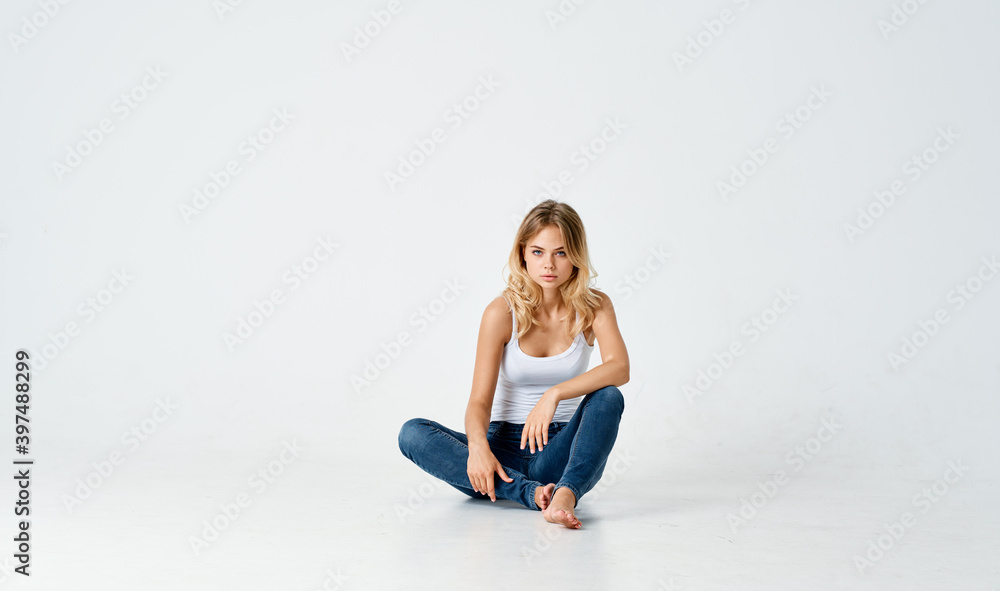 women legs crossed sitting on the floor indoors in jeans and t-shirt women legs crossed sitting on the floor indoors in jeans and t-shirt