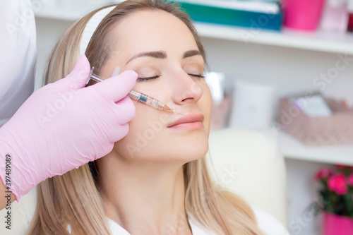 young woman receiving cosmetic injection. Woman in a beauty salon. Plastic Surgery Clinic.