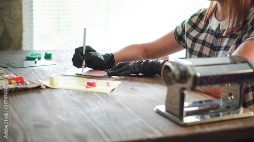 Small business concept. Professional artisan works with polymer clay at workshop.