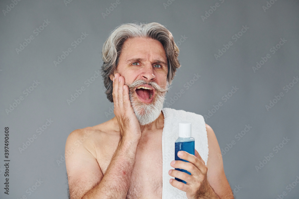 Fresh and clean face. Stylish modern senior man with gray hair and beard is indoors Fresh and clean face. Stylish modern senior man with gray hair and beard is indoors