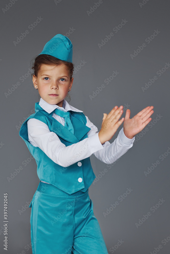 Cute little girl in blue stewardess uniform is posing for the camera Cute little girl in blue stewardess uniform is posing for the camera