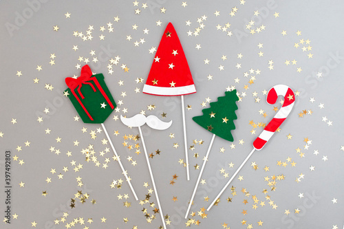 On  gray background with golden stars are christmas and new year steakers, red hat, gift, chrstmas tree. Xmas decor. flatly.top view.