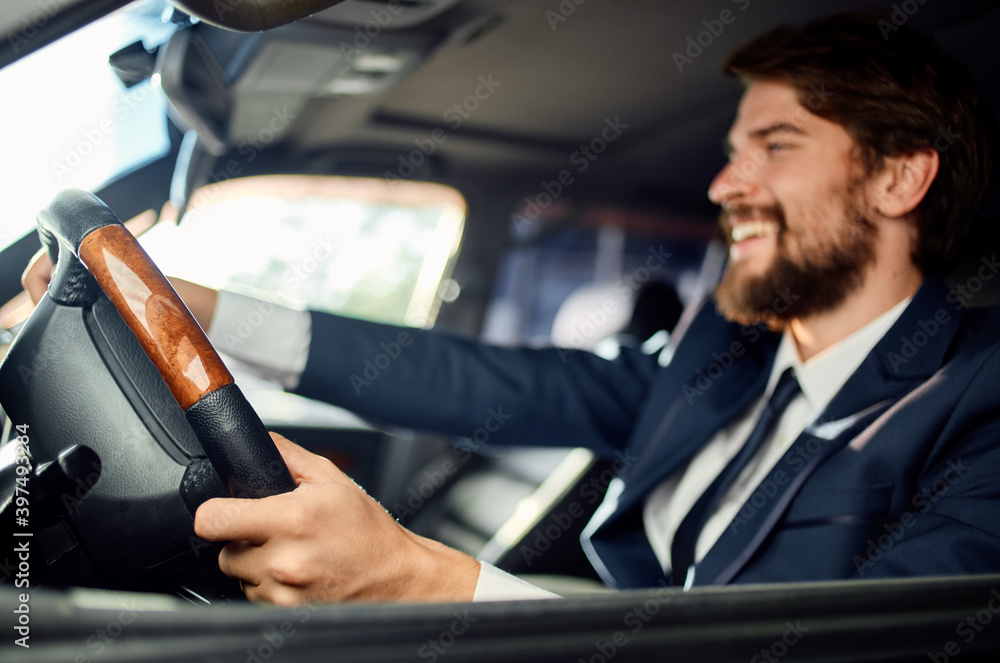 bearded man sitting in car salon in suit success trip lifestyle