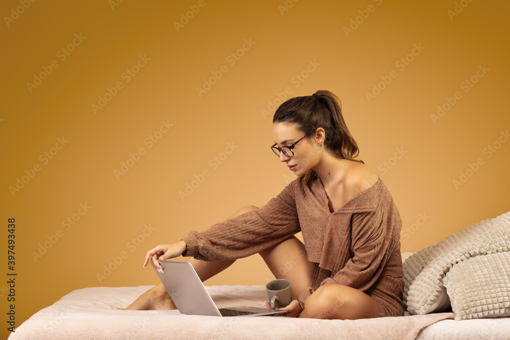 Portrait of a young woman sitting at her computer, a cup of tea in her hand Portrait of a young woman sitting at her computer, a cup of tea in her hand