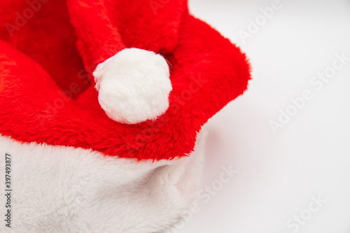 Santa Claus hat on white table with blank space to the right side. © cupeles