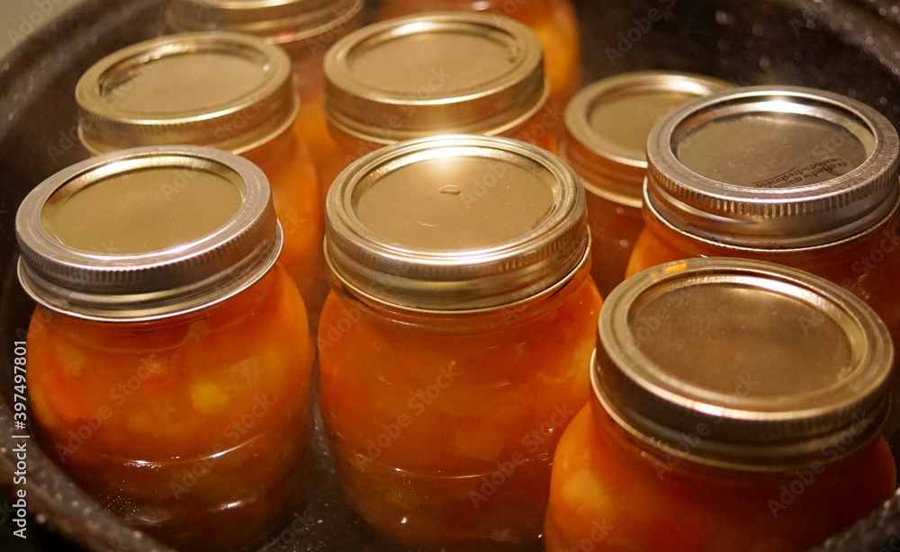 Close-up of of glass jars full of homemade fruit ketchup being sterilized in boiling water
Close-up of of glass jars full of homemade fruit ketchup being sterilized in boiling water