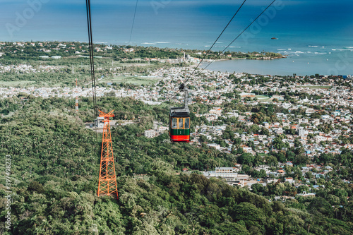 Foto Cable car on a cableway (teleferico) over the city and green mountain in Puerto