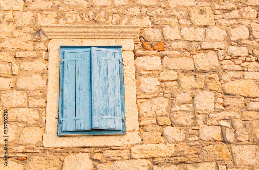 Window with blue shutters on a stone building Window with blue shutters on a stone building