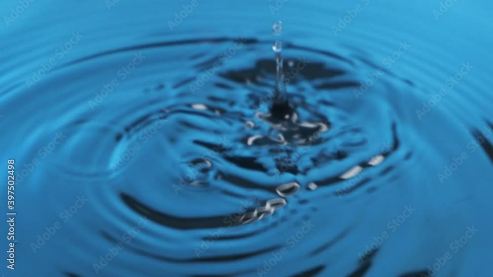 Slow motion. Two droplets of water falling into blue, clean, cold water. Blue water drops, splash and ripple Slow motion. Two droplets of water falling into blue, clean, cold water. Blue water drops, splash and ripple