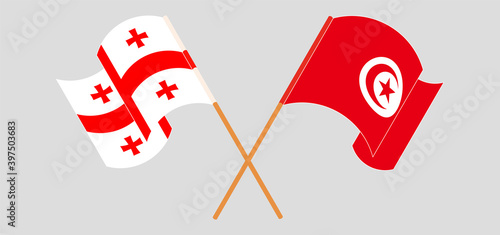 Crossed and waving flags of Georgia and Tunisia