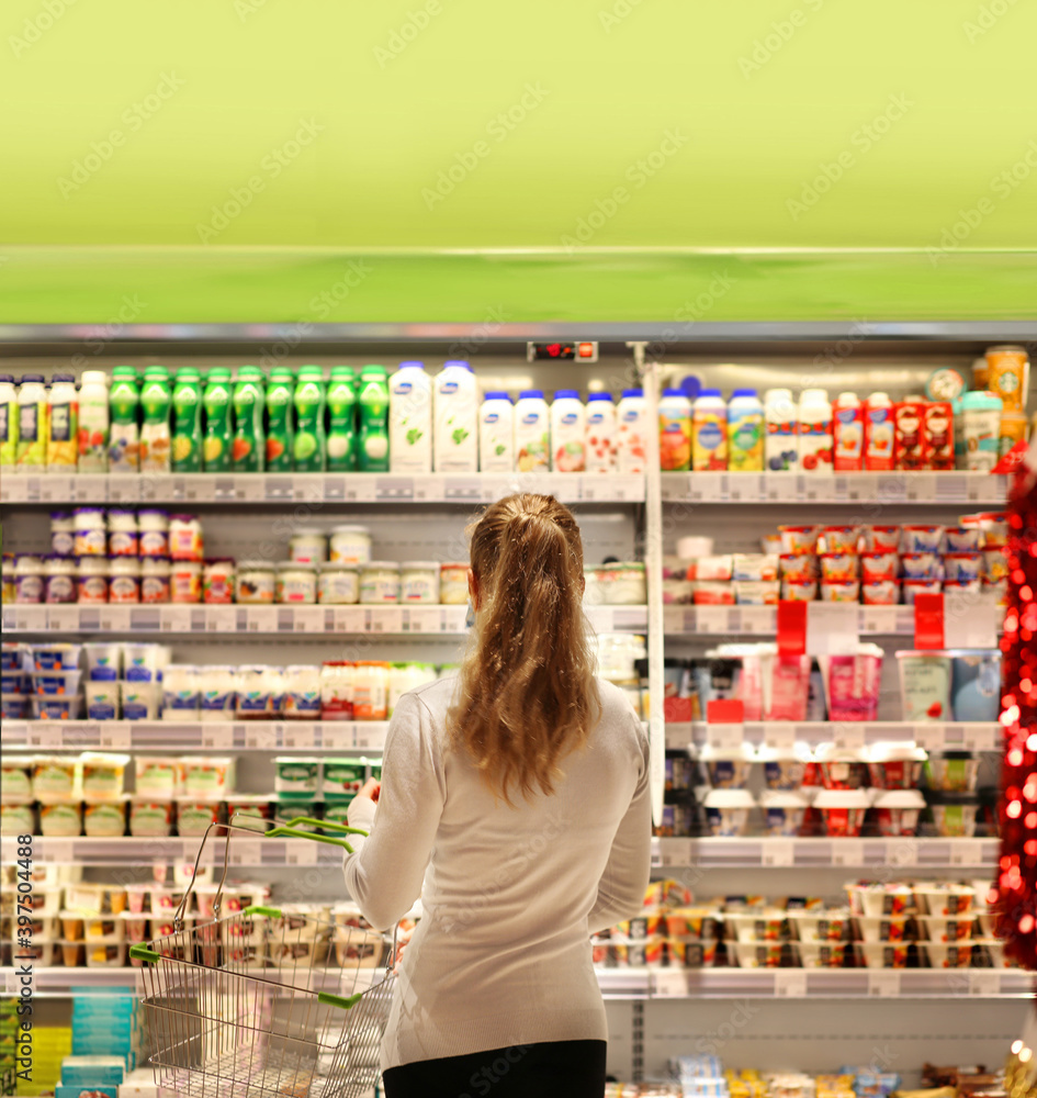 supermarket shopping, face mask,Woman choosing a dairy products at supermarket. supermarket shopping, face mask,Woman choosing a dairy products at supermarket.