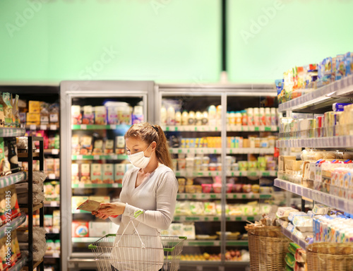 supermarket shopping, face mask,Woman choosing a dairy products at supermarket. © lado2016