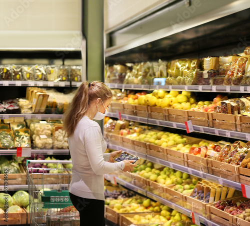 Supermarket shopping, face mask ,woman buying fruits at the market.