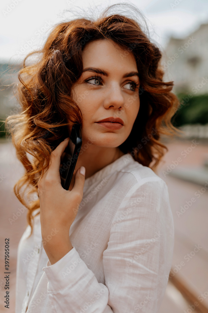 Close up portrait of charming stylish lady with red hair looking away with lovely smile on the street Close up portrait of charming stylish lady with red hair looking away with lovely smile on the street
