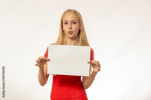 Teenage girl with blond hair in red dress holds paper