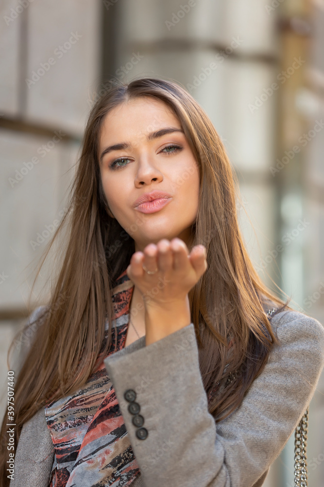 Young woman sending air kiss to camera