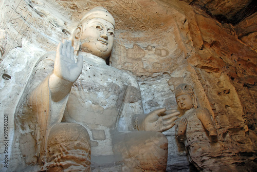 Yungang Grottoes near Datong in Shanxi Province, China. Large ancient statue of Buddha in a cave at Yungang. Landscape view from side. Yungang Buddhist cave art and sculptures UNESCO world heritage.