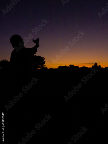 silhouette of a boy with paper plane