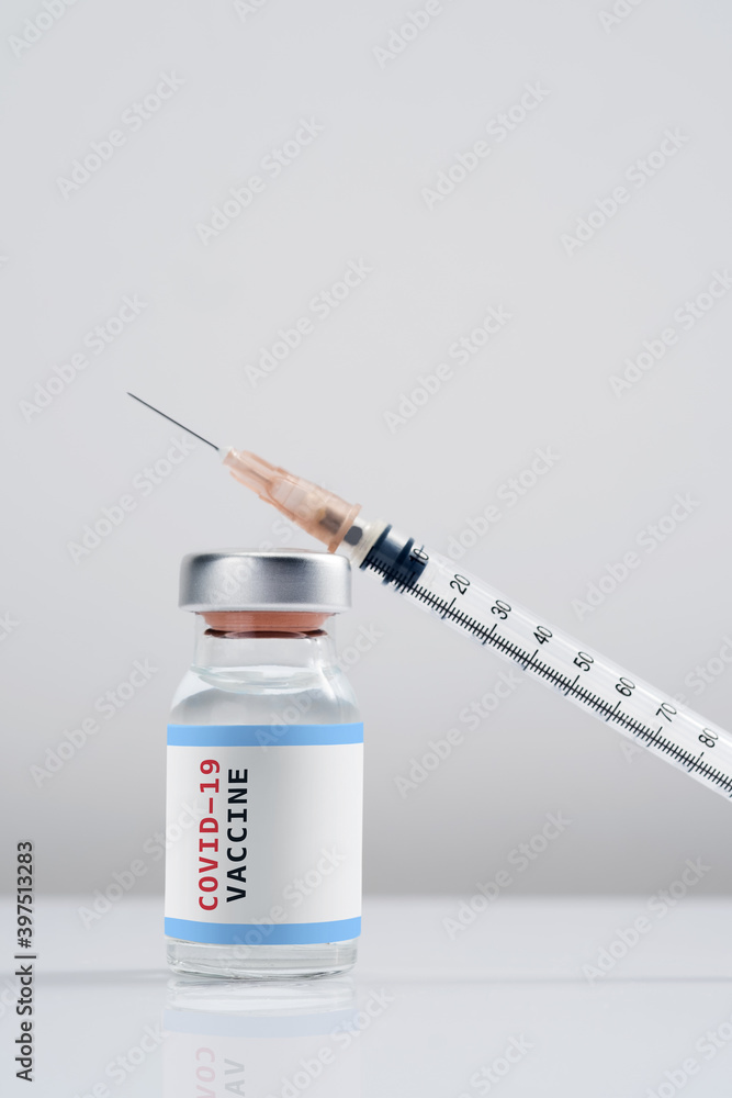 Covid-19 Written vaccine bottle with a syringe on a white background Covid-19 Written vaccine bottle with a syringe on a white background