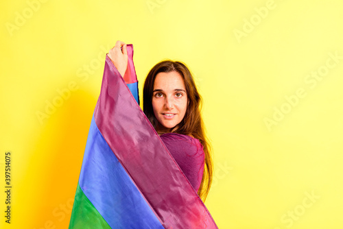 Young woman rolled up in a gay pride flag.