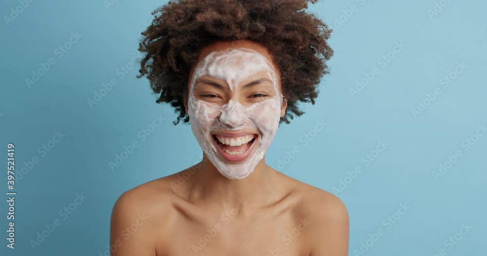 Emotional young woman appears on blue background raises palms says boo