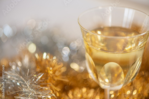A glass of Champagne and Christmas decorations on a white background